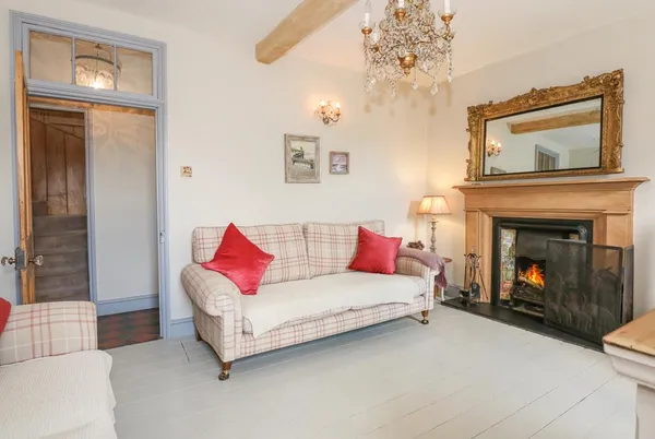 Malthouse Farm living room with fireplace, plaid sofa, and chandelier