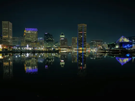 Baltimore's Inner Harbor and illuminated skyline reflected at night