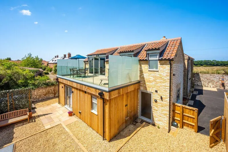 May Cottage Titchwell stone and timber property with glass balcony and garden