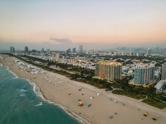 Aerial view of Miami Beach, beachfront towers, and the ocean at dusk