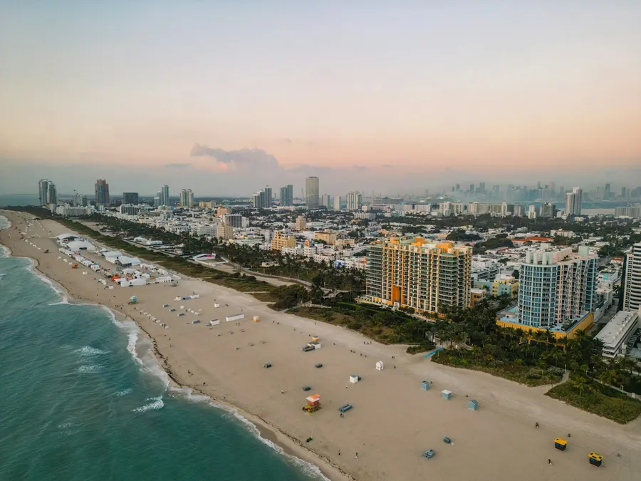 Aerial sandy beach lined with high-rises at dusk