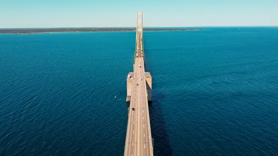 Aerial view of a long bridge over deep blue water