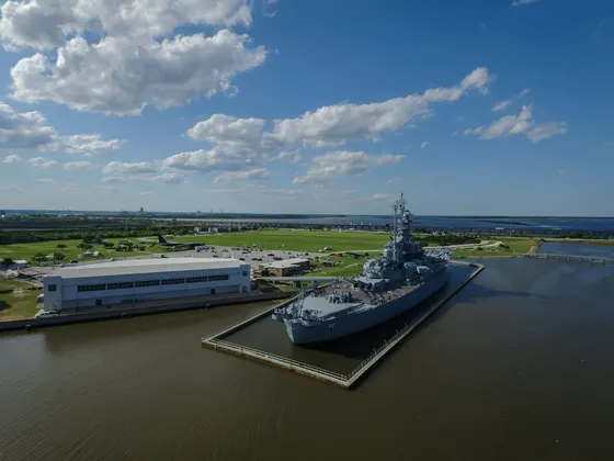 USS Alabama battleship docked in Mobile Bay beneath a blue sky