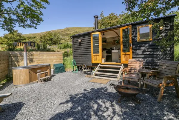 Moelfre Shepherds Hut exterior with hot tub and steps