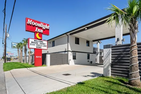 White motel with a red Moonlight Inn sign and crescent moon