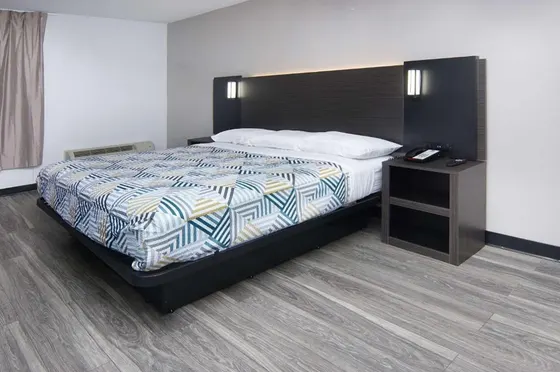 Room with geometric bedding and a dark wood headboard