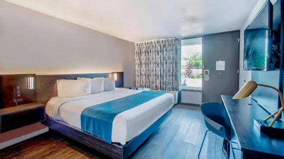 Bright room with a teal bed runner and a desk