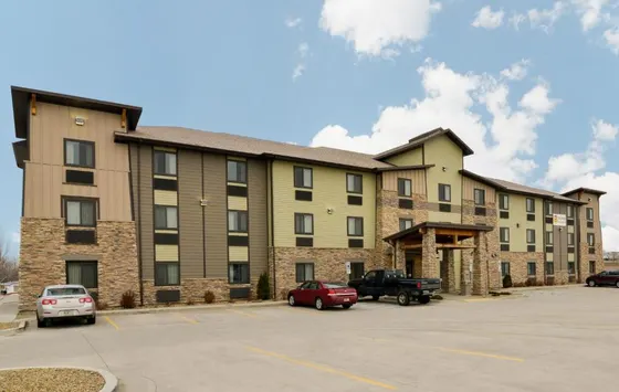 Large apartment building with cars parked in a parking lot