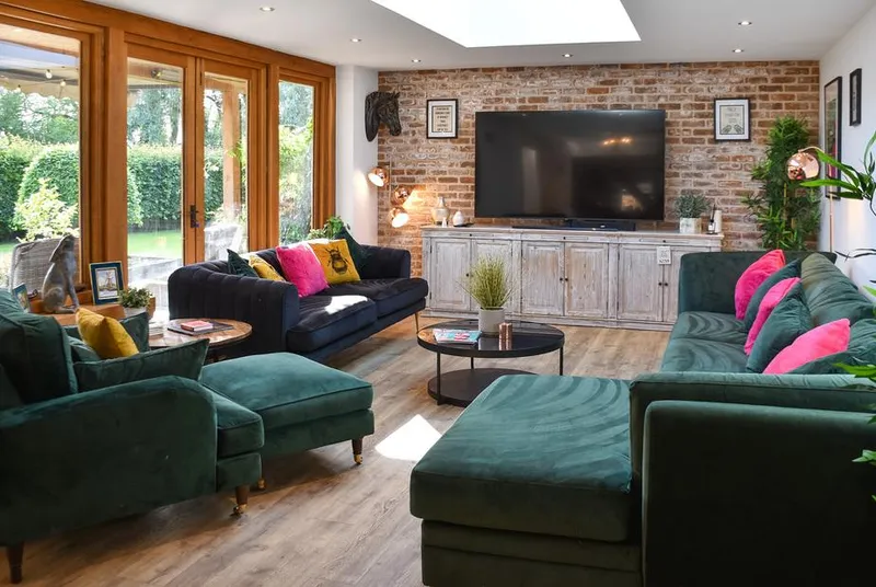 Myrtle Cottage open-plan living room with velvet sofas and exposed brick
