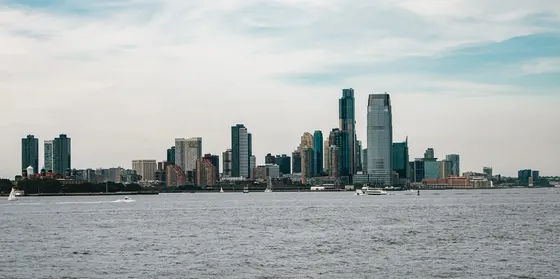 Jersey City skyline across the Hudson River with boats on the water