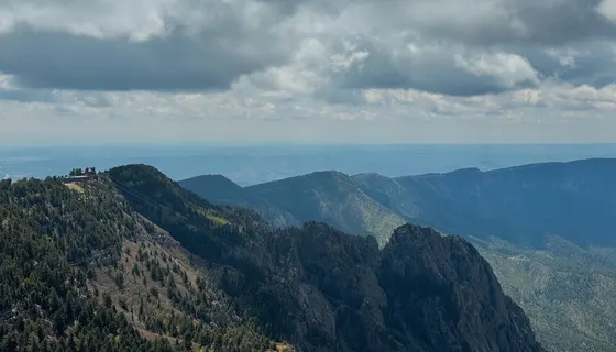 Sandia mountain ridges and tram cables under clouds