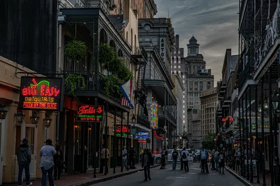 Bourbon Street at dusk with neon restaurant signs