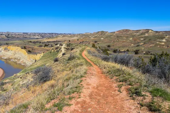 Red dirt trail along a ridge above a river valley
