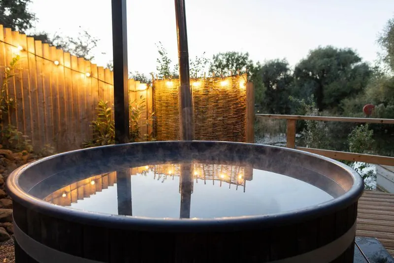Oak Lodge At Bridge Lake Farm & Fishery steaming hot tub at dusk