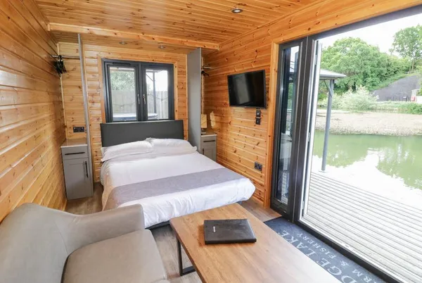 Oak Lodge At Bridge Lake Farm & Fishery studio interior with bed and water view