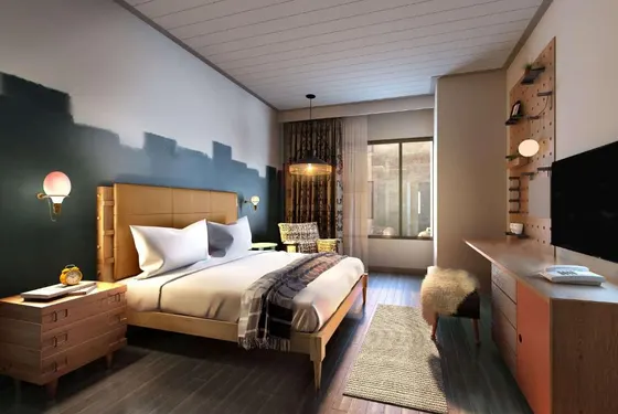 Room with a tan headboard, blue mural, and wooden desk
