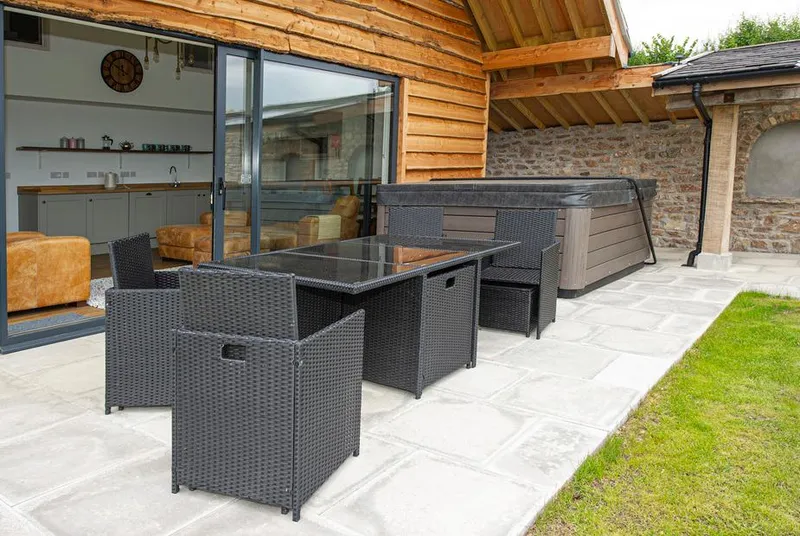 Owl Lodge patio with outdoor dining, hot tub, and bi-fold doors open