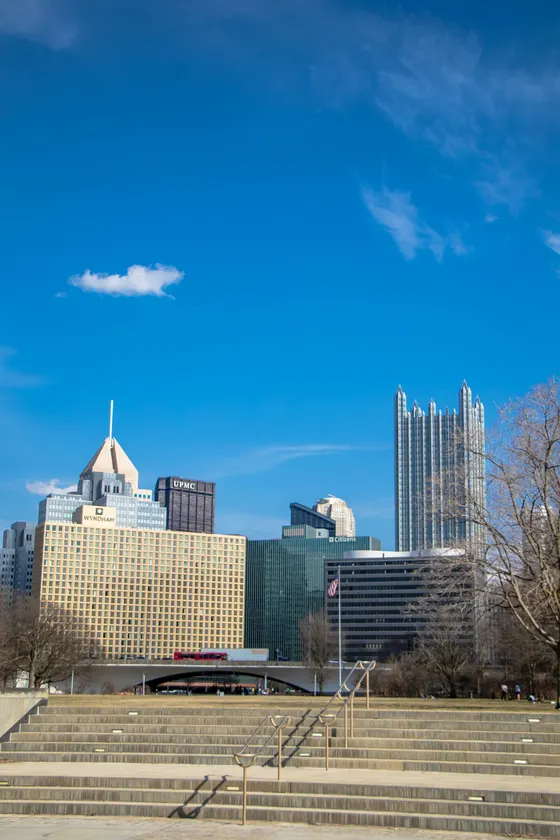 Pittsburgh skyline beyond park steps under a clear blue sky