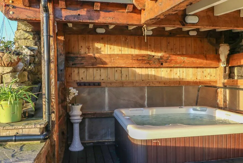 Flatt House Barn hot tub under rustic timber shelter