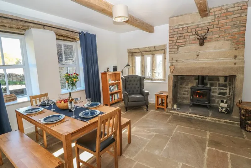 The Cottage, Beeston Hall dining room with beams and lit wood burner