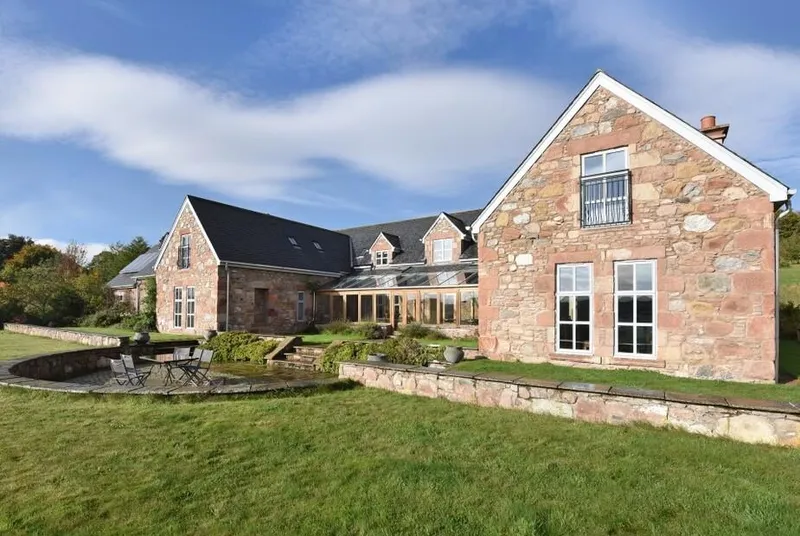 Quarryfield stone house exterior with patio and lawn