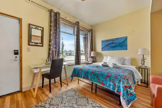 Bedroom with a bed and a desk and a window