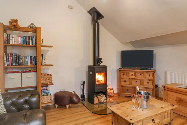 Ramblers Retreat living room with lit wood burner and champagne