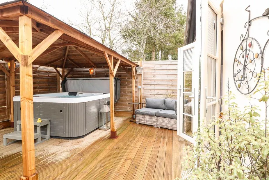 Red Brick Retreat hot tub under oak-frame gazebo on bright decking