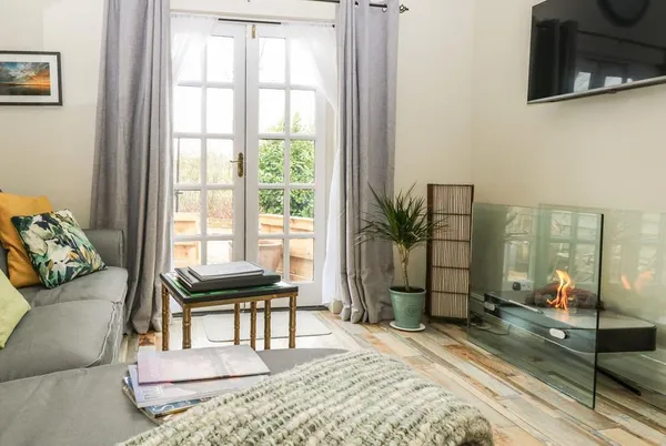 Red Brick Retreat living room with lit glass fireplace and sofa