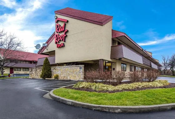 Tan Red Roof Inn with brown balconies and a parking lot