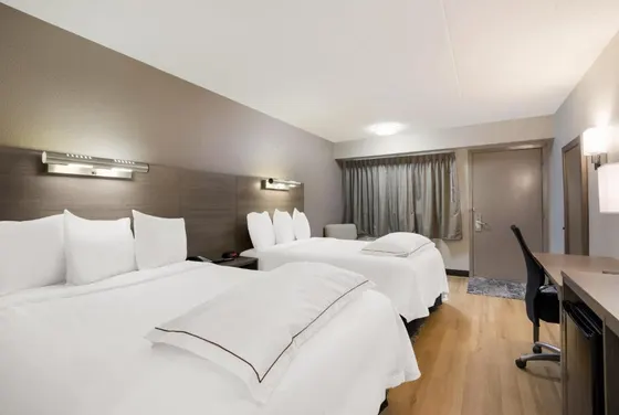 Hotel room with two beds with white sheets