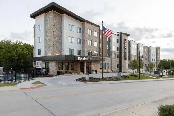 Stone hotel with a Residence Inn canopy and an American flag