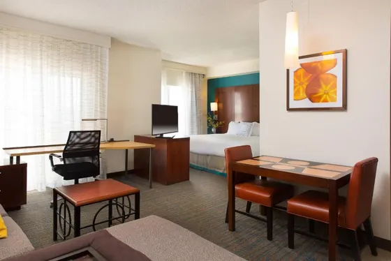 Hotel room with a bed and a desk and a table