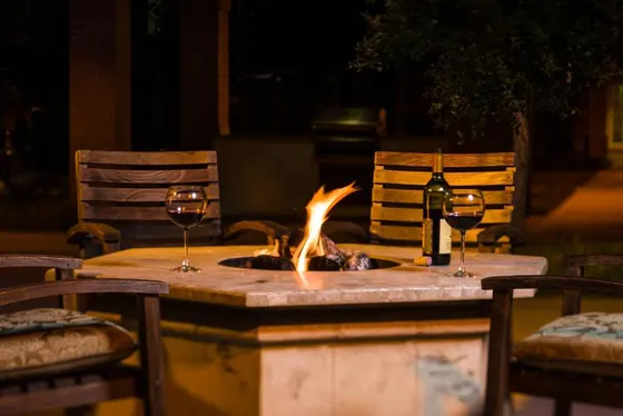 Table with two wine glasses and a fire pit
