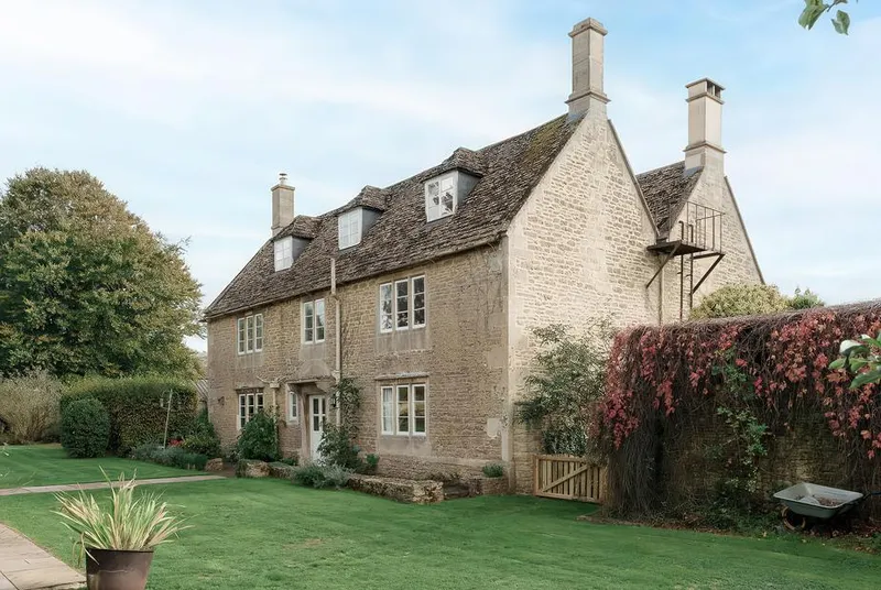 Reybridge House Cotswold stone facade with autumn ivy and manicured lawn