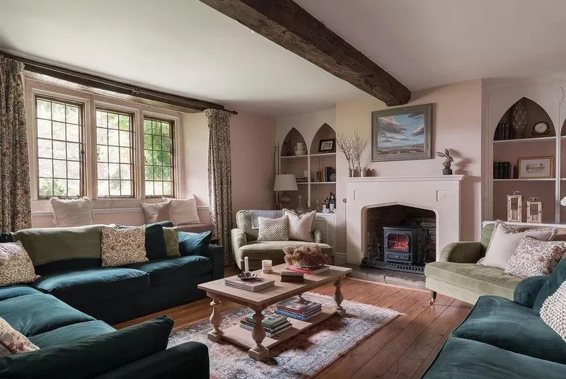 Reybridge House living room with teal sofas, fireplace and Gothic arch alcoves