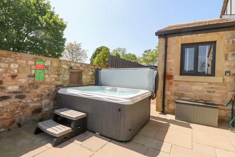 Ribble View hot tub on a stone patio beside the lodge