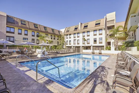 Large swimming pool with chairs and buildings