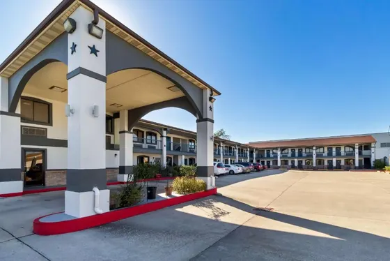 Two-story motel with a covered entry and red-bordered parking