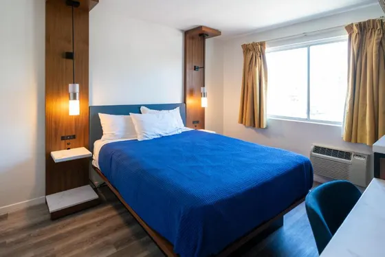Bedroom with a blue bed and a window