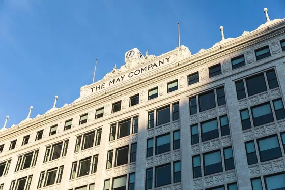 White historic facade with a clock and The May Company sign