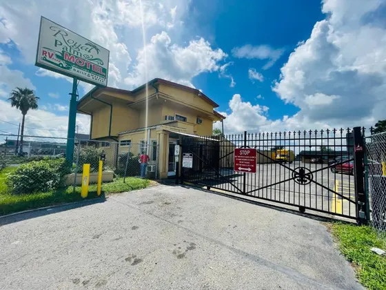 Yellow motel office behind a gate with a Royal Palms sign