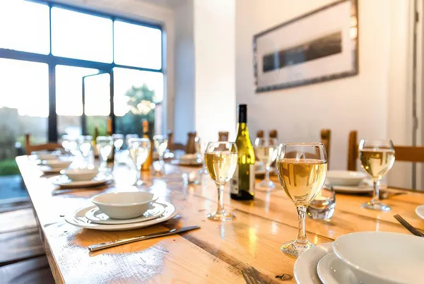 Royal Victoria House dining table set with wine glasses in golden hour light