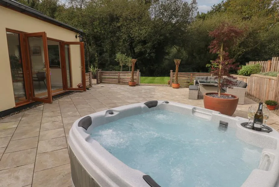 Rudbaxton Water hot tub on the broad patio beside the house