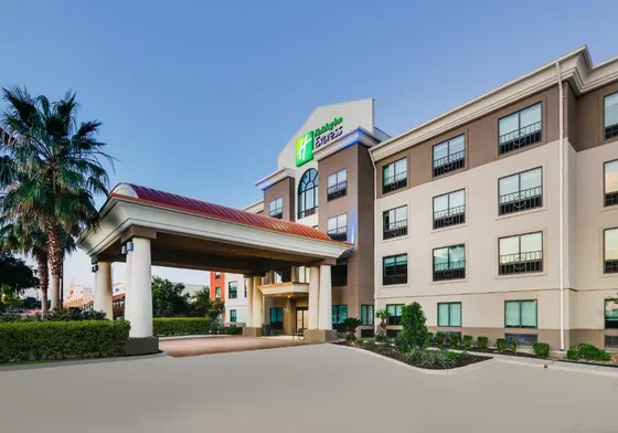 Holiday Inn Express with a red-roofed portico and palm trees