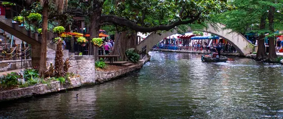 Stone arch bridge over the tree-lined River Walk