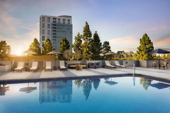 Swimming pool with chairs and a building in the background