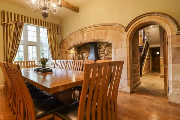 Scale House dining room with stone archway and wood burner