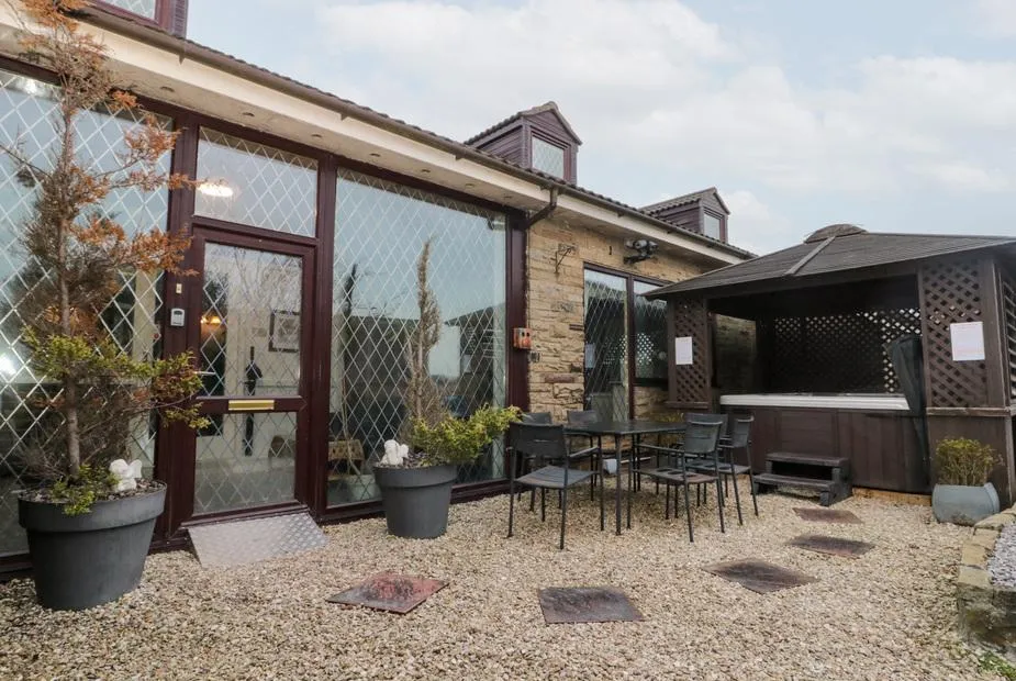 Seacrest Lodge patio area with hot tub under wooden pergola