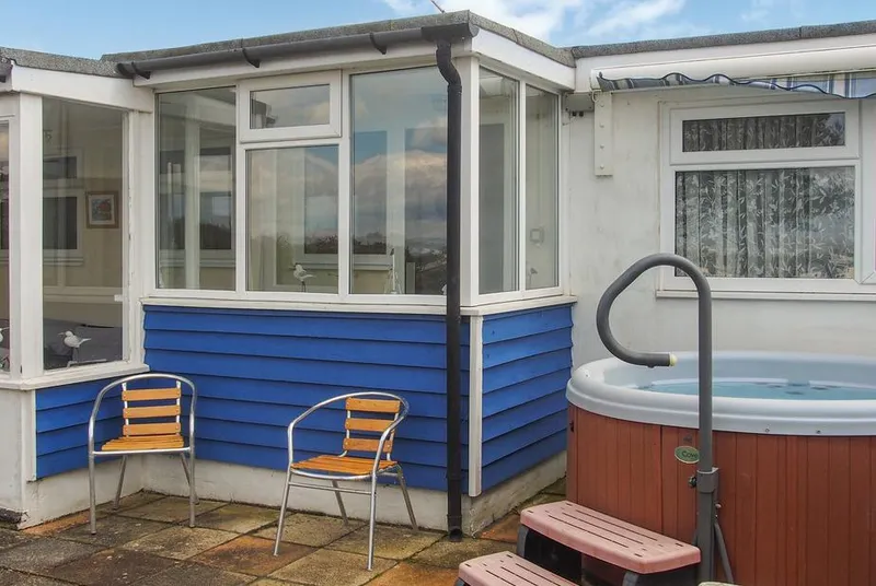 Seagull Cottage hot tub beside blue-clad conservatory